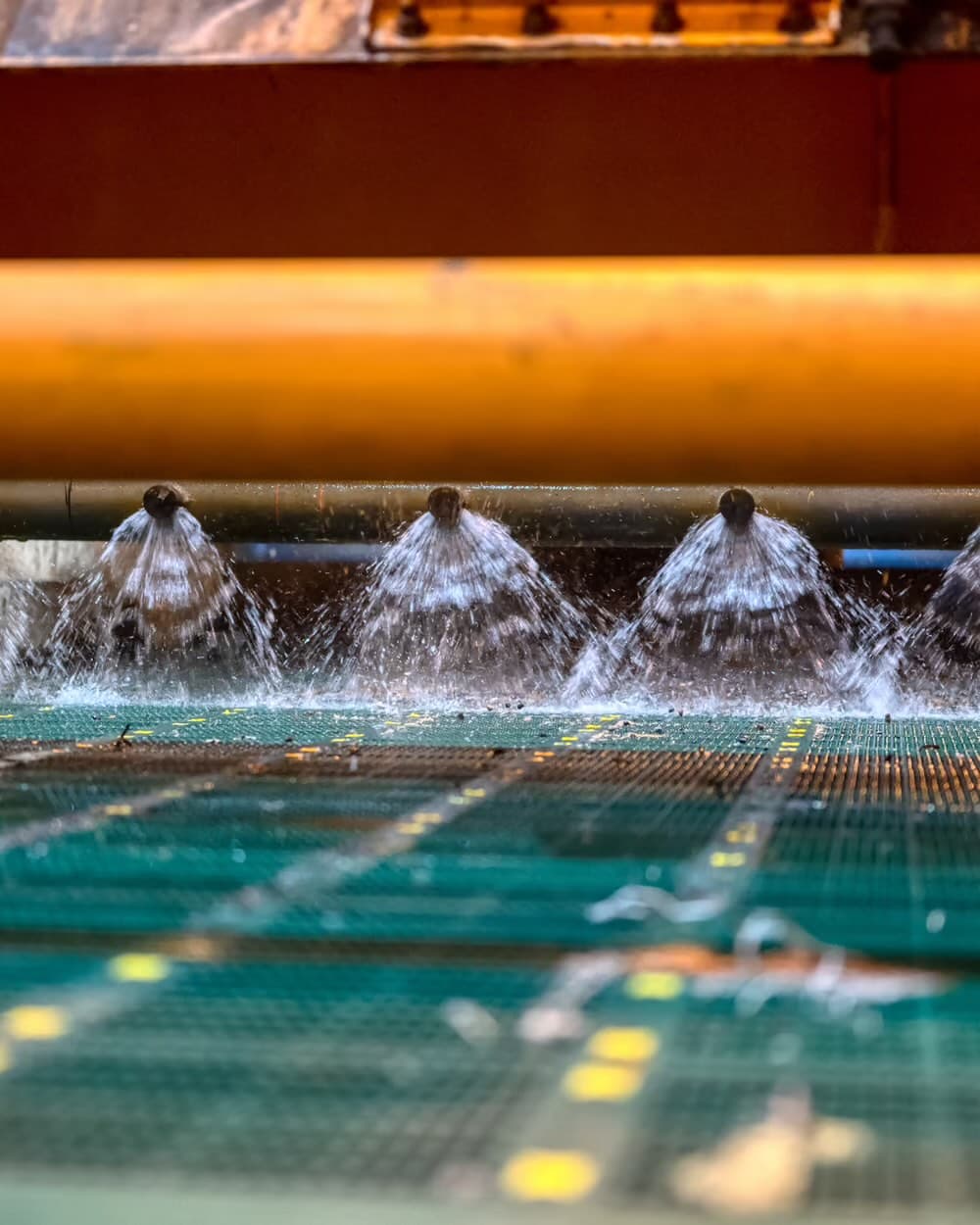 Jets of water spraying across an industrial water-treatment line.